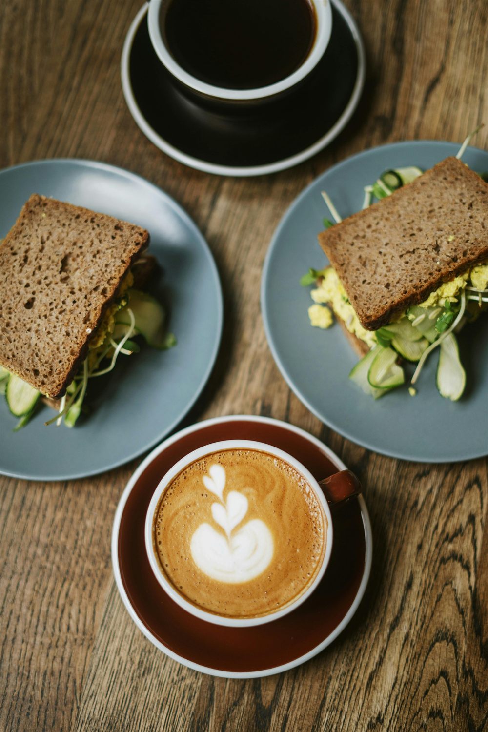 Café y sándwiches sobre una mesa, imagen representativa de cafetería.
