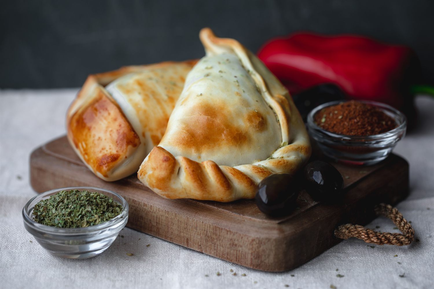 Empanadas doradas sobre una tabla con especias, imagen representativa de comida rápida salada.